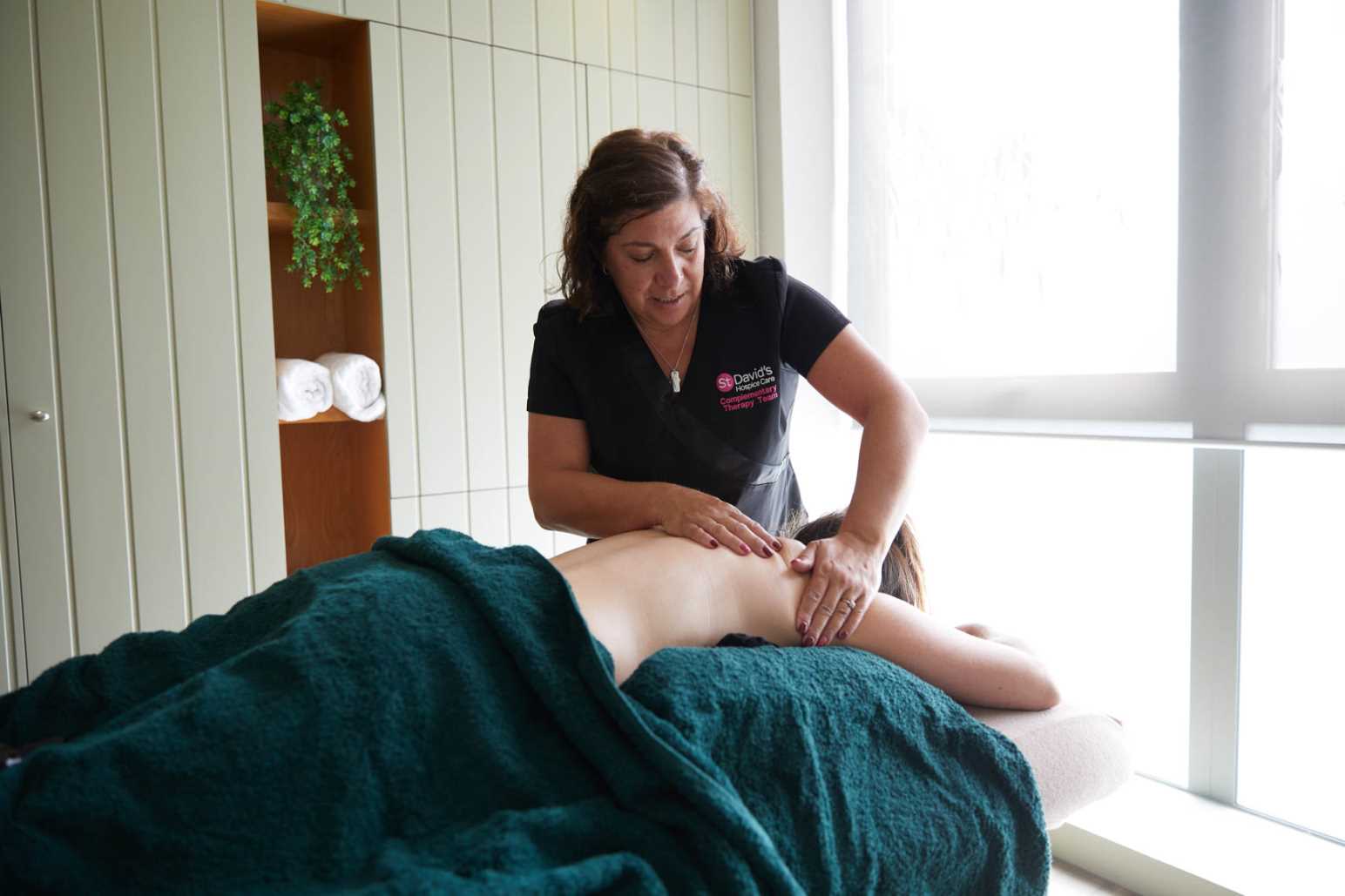 Complementary therapist massages patient.