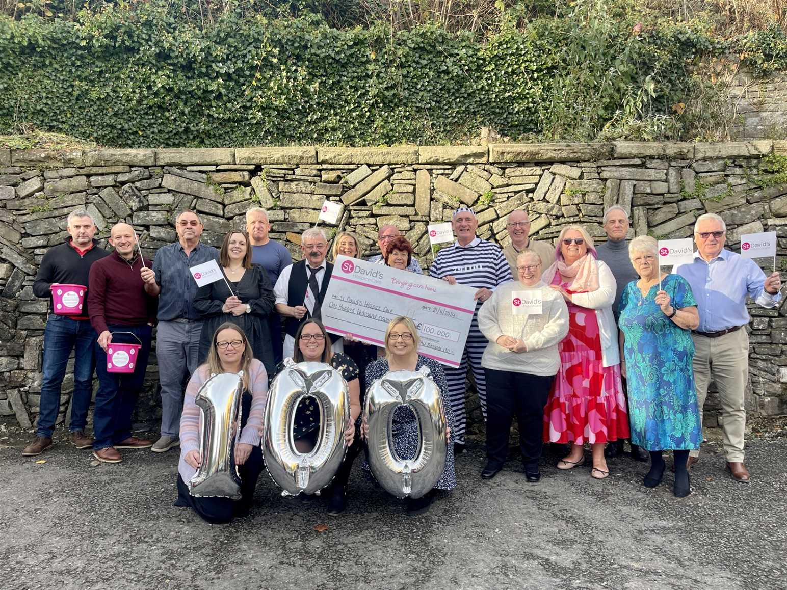 Phil Bessant and the team of supporters celebrating the £100,000 milestone